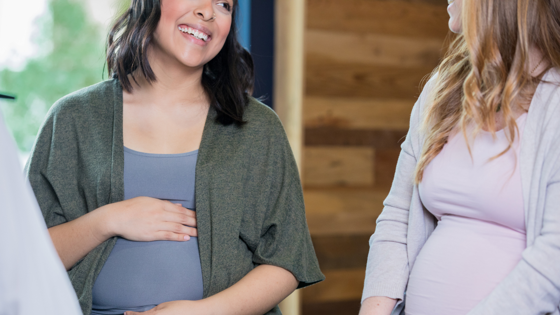 Deux femmes enceintes se regardent, se sourient en discutant de la sexualité pendant la grossesse.
