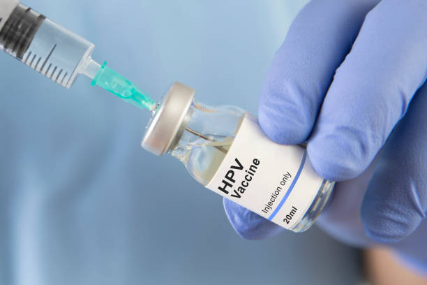 Main gantée injectant le vaccin contre le papillomavirus dans une seringue